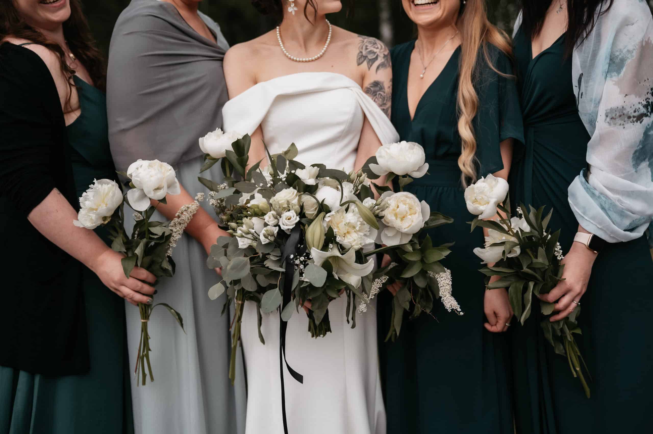 Brud med blomsterbukett og veninner i bryllupsklær.