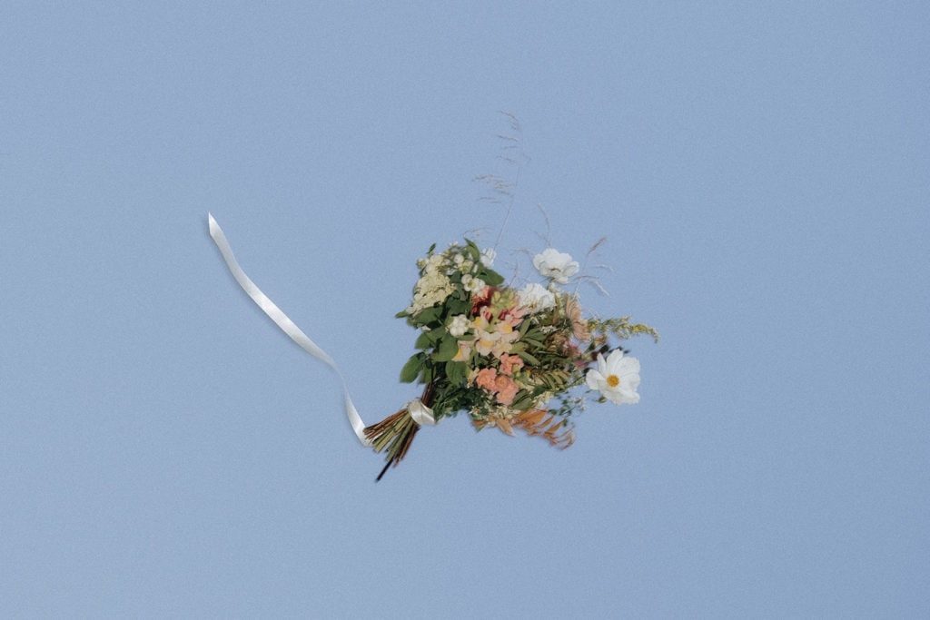Blomstert bouquet med hvit og rosa blomster på blå bakgrunn.