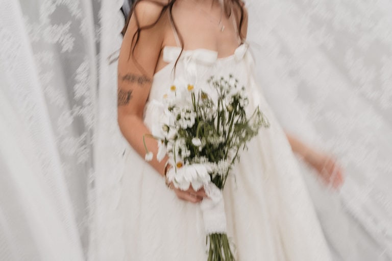 Nydelig brud med blomsterbukett i hvit brudekjole.