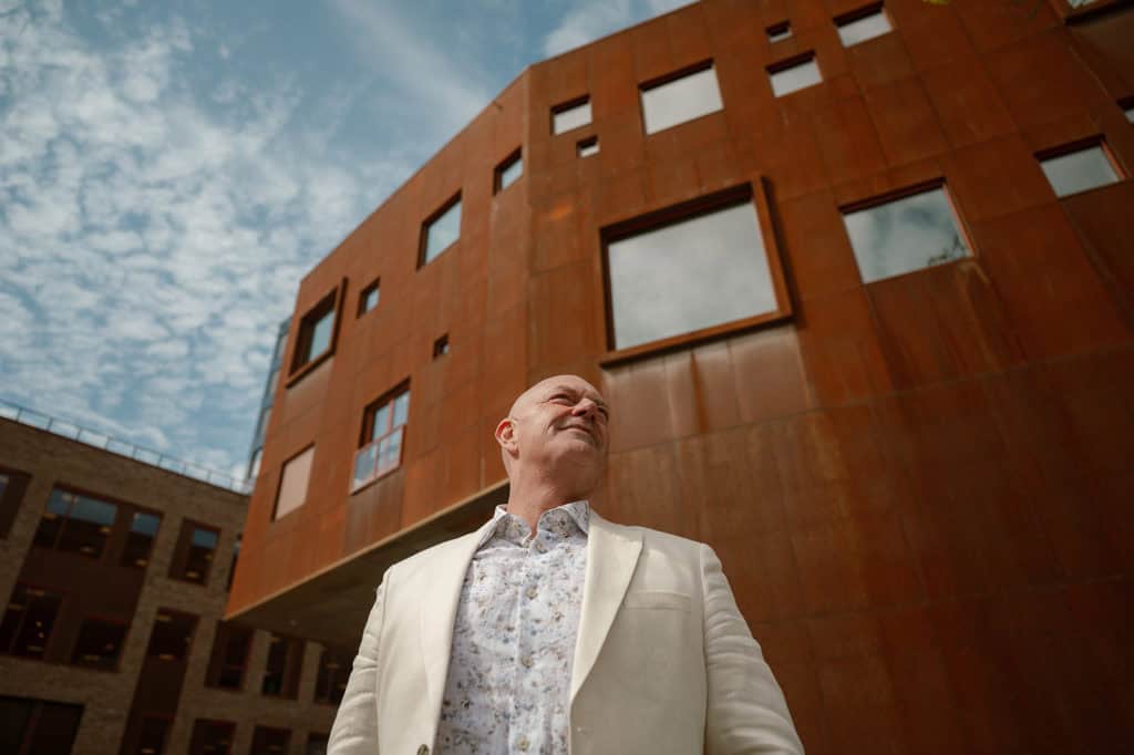 Moderne arkitektur med rustfargede fasader og skyfri himmel.