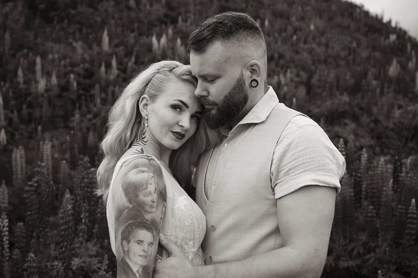 Par et i naturen med kjærlighet og tatoveringer i svart-hvitt.