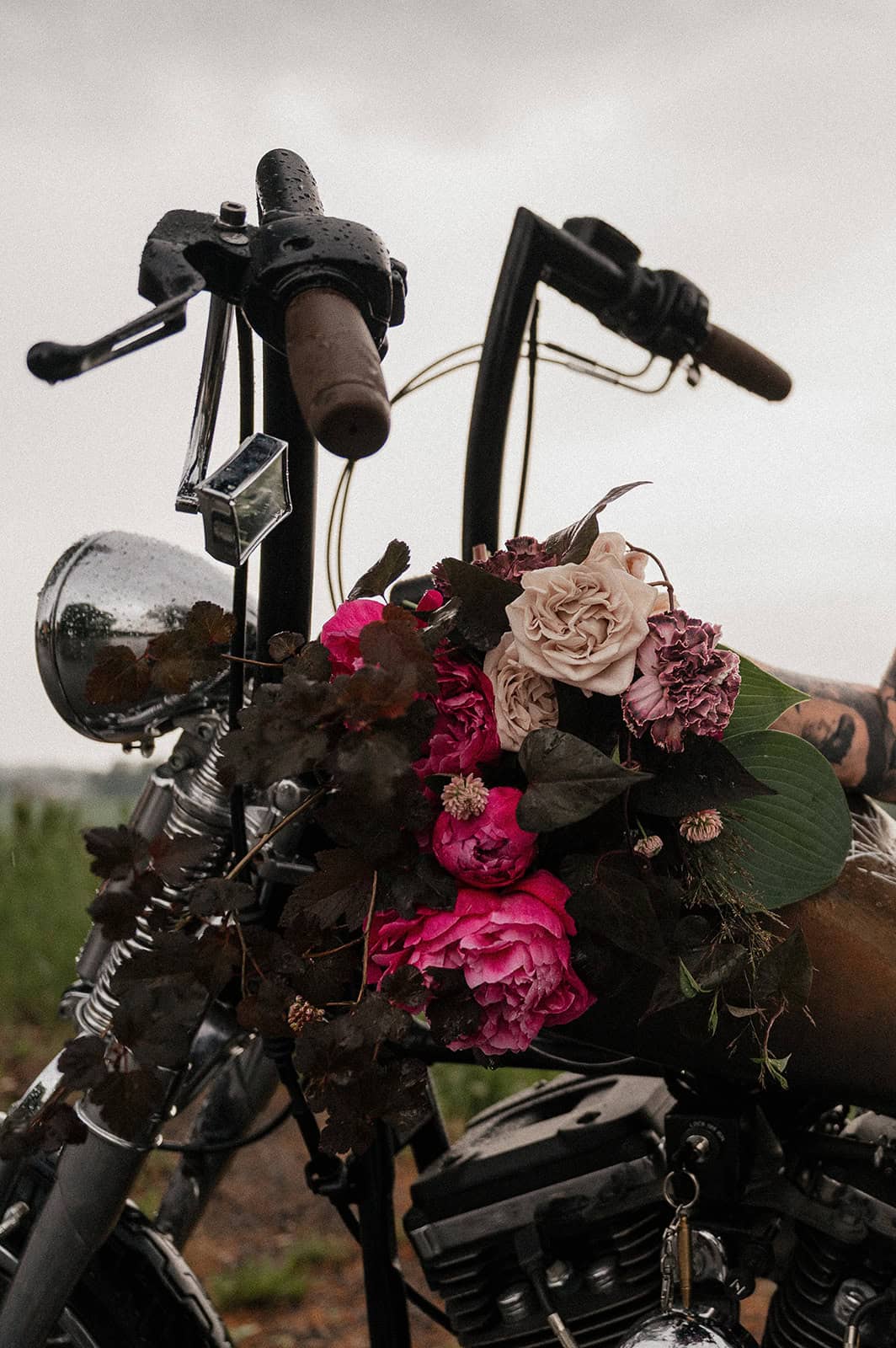 Vintage motorsykkel med blomsterdekorasjon i naturen.